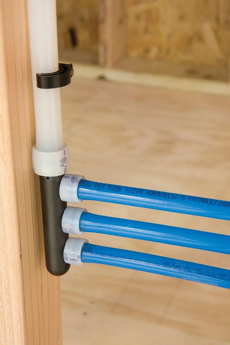 Blue PEX lines leaving a manifold fastened to a wall stud, from our San Clemente guide: Planning a Rinnai Tankless Water Heater Installation for Your San Clemente Home